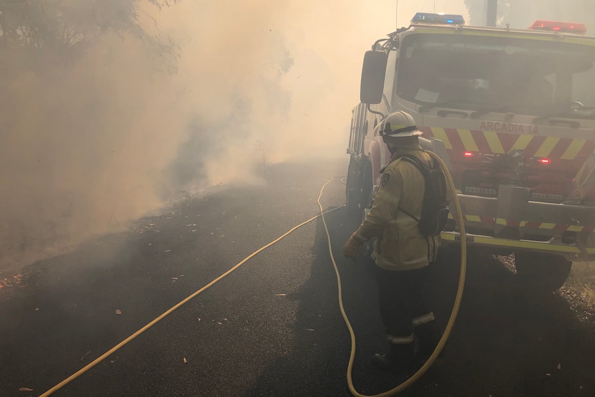 a man wearing a helmet and protective suit engulfed in dark smoke