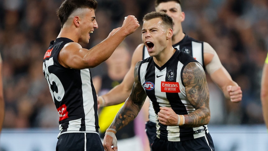 Jamie Elliott pumps his fist and yells in delight as teammates celebrate with him