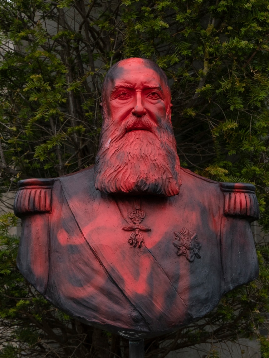 A bust of Belgium's King Leopold II is smeared with red paint and graffiti.