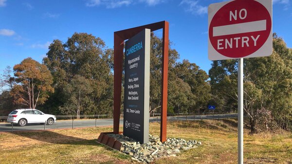 A car crosses the border into Canberra on a sunny day.