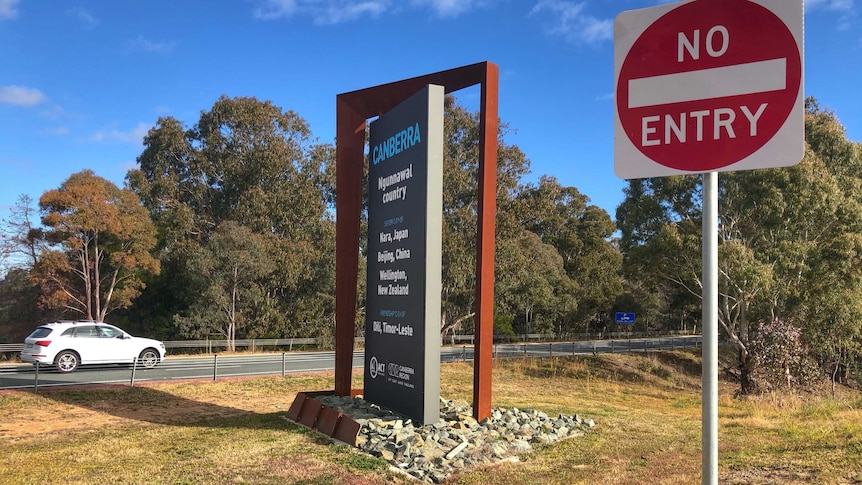 A car crosses the border into Canberra on a sunny day.