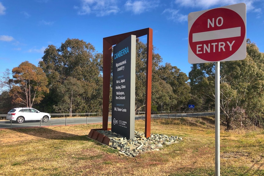 A car crosses the border into Canberra on a sunny day.