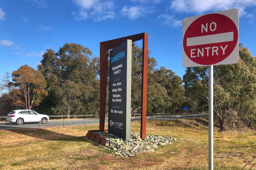 A car crosses the border into Canberra on a sunny day.