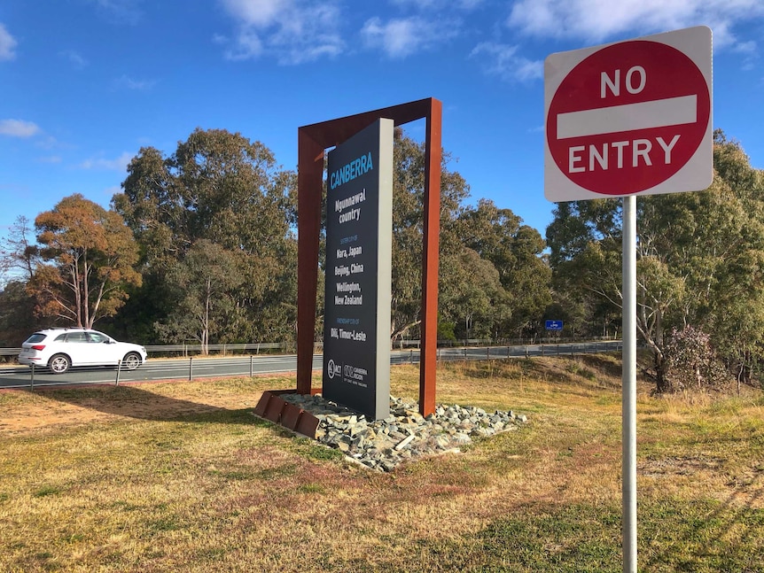 A car crosses the border into Canberra on a sunny day.