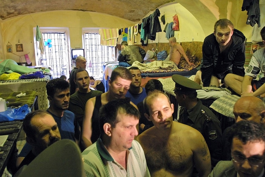 More than 10 inmates crammed in a small room with bunk beds.