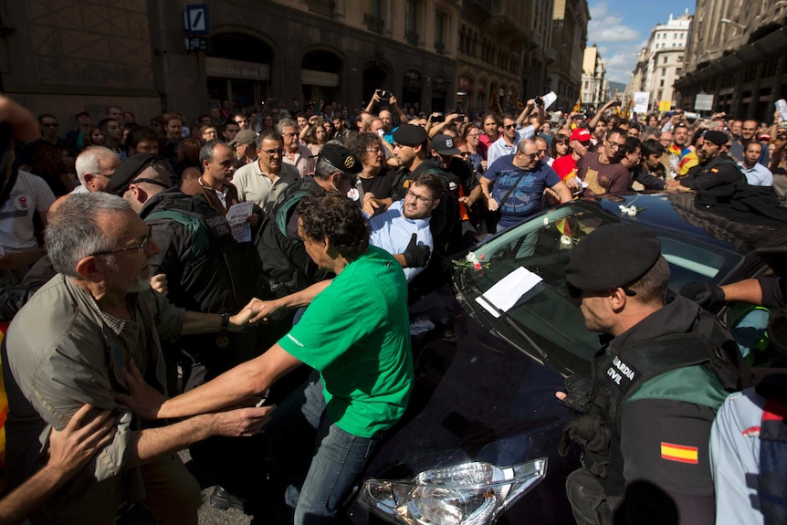 Protesters throw themselves in front of a car.