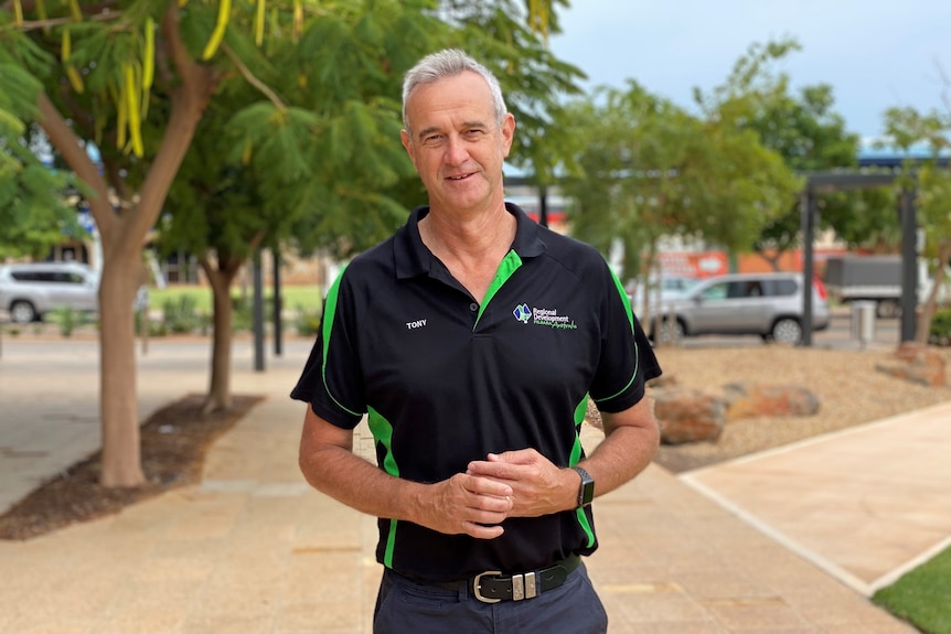 A man standing in front of trees.