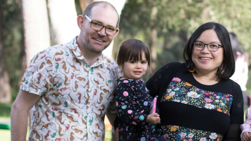 A family portrait of a woman, man and their daughter.