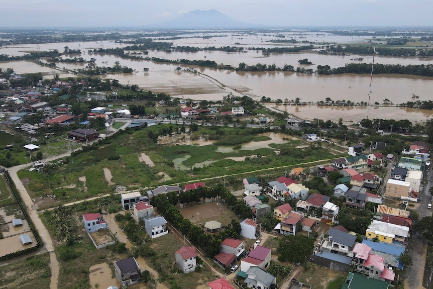 An aerial shot shows flooded residential areas and fields streting far into the distance.