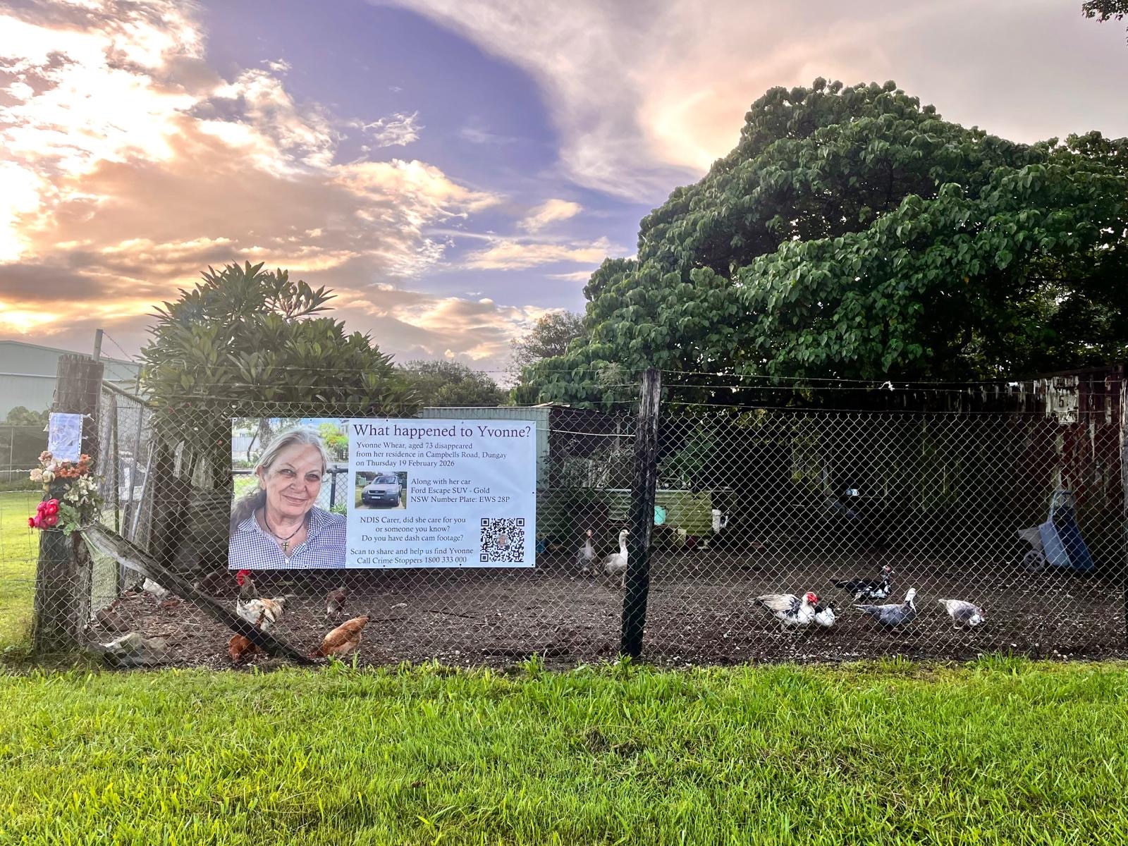 A missing person sign stuck to a mesh chicken enclosure on a country property.