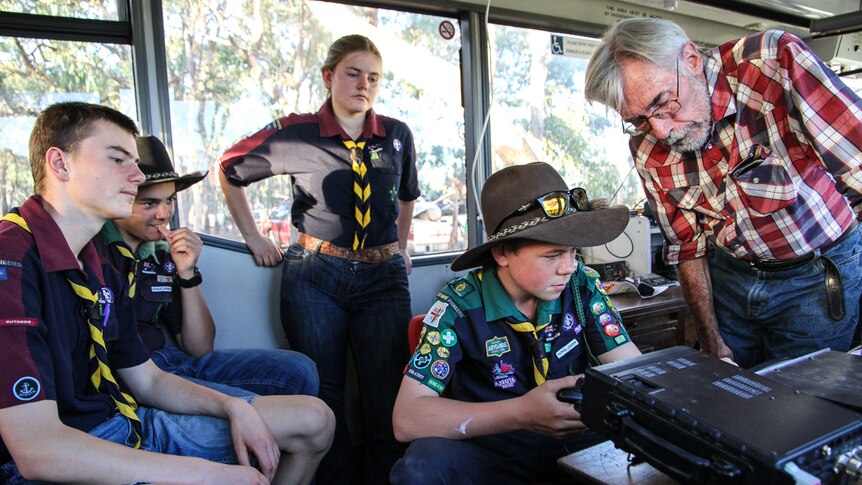 Trainer Tony Falla showing the Castlemaine Venturers how to tune in on the amateur radio equipment  from the inside of a bus.