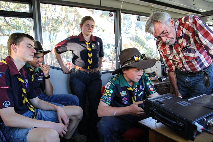 Trainer Tony Falla showing the Castlemaine Venturers how to tune in on the amateur radio equipment  from the inside of a bus.