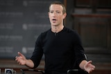Mark Zuckerberg gesturing while wearing a black shirt and mic.