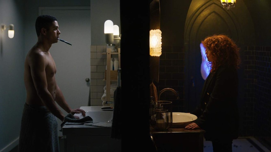Split-screen still featuring two bathrooms: one minimalist with man brushing teeth, another grungy with woman staring in mirror.
