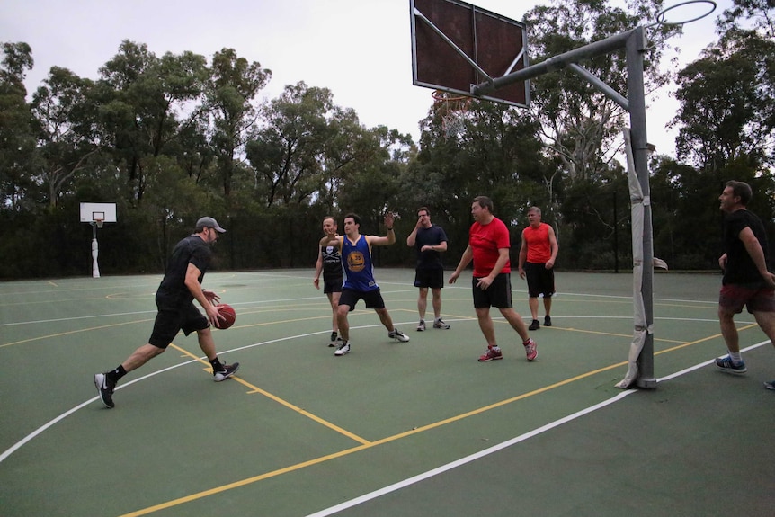 Labor's Ed Husic dribbles the ball in a politicians' game of basketball.