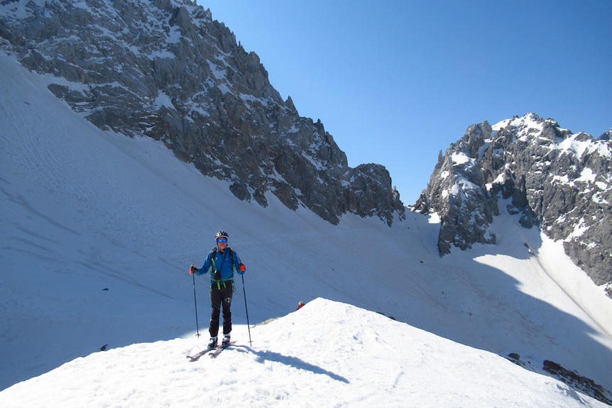 Dr Vogelmann on skis with a helmet and poles on pristine snowy slopes