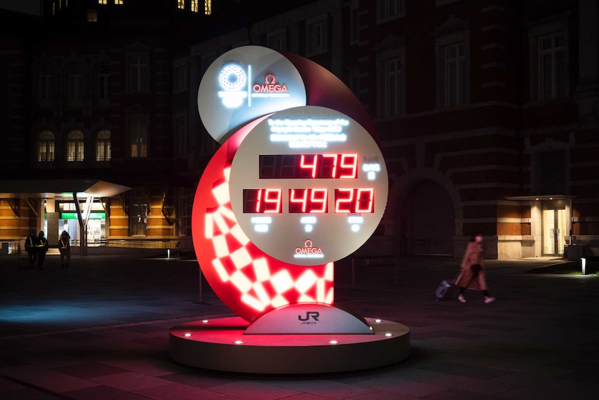 A clock glows in the night, showing days, hours, minutes and seconds left to the Tokyo Olympics.
