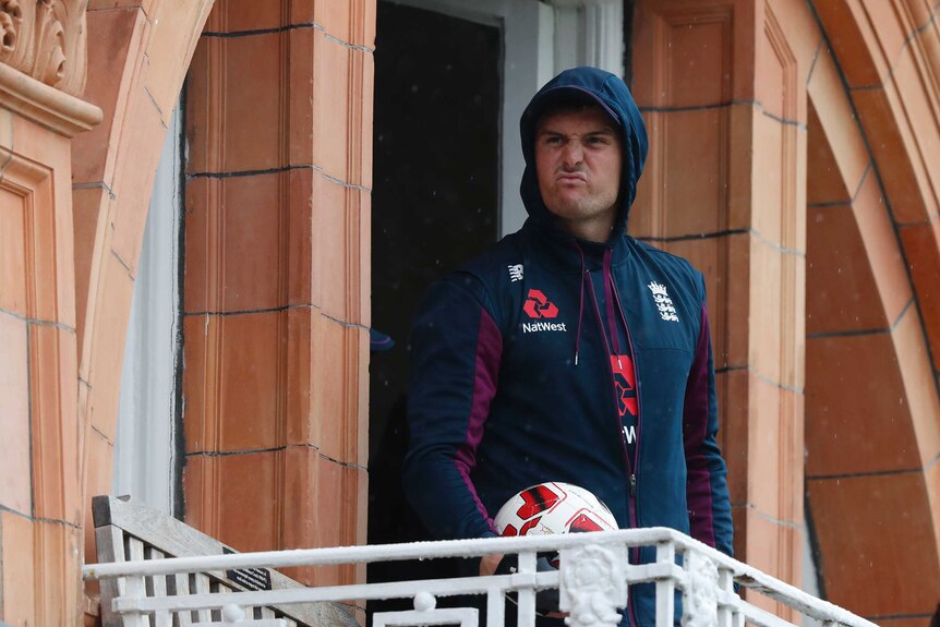 England player Jason Roy screws up his face while watching rain from a dressing room balcony at the second Ashes Test at Lord's.