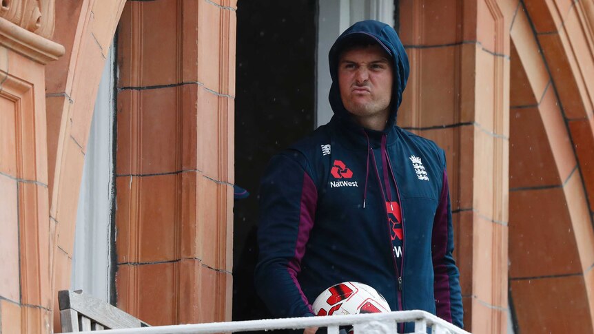 England player Jason Roy screws up his face while watching rain from a dressing room balcony at the second Ashes Test at Lord's.