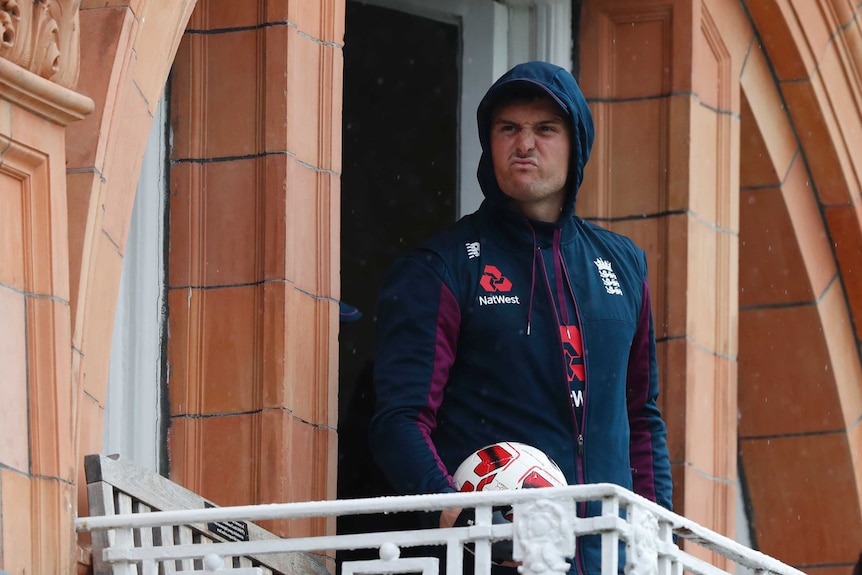 England player Jason Roy screws up his face while watching rain from a dressing room balcony at the second Ashes Test at Lord's.