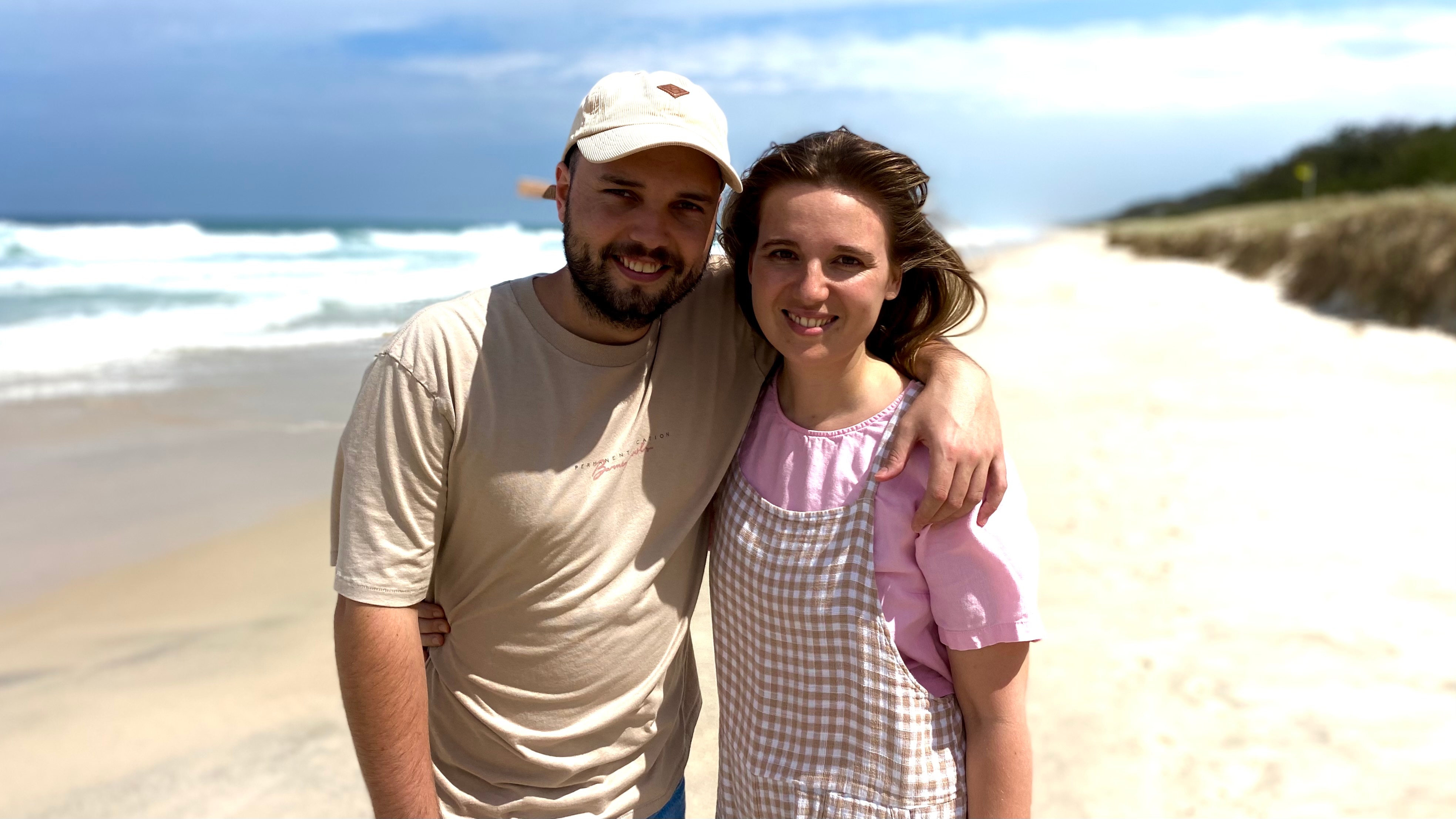 A young couple walking along the beach.