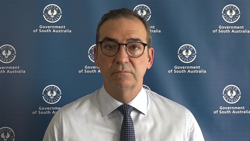 A man wearing a white shirt and glasses speaking