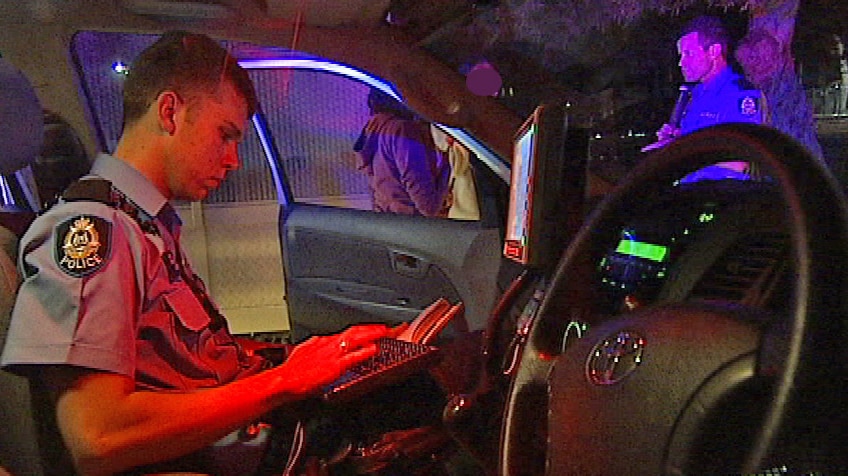 Officer checks laptop in car. (file)
