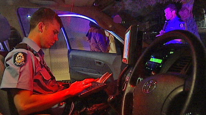 A police officer checks details on a laptop