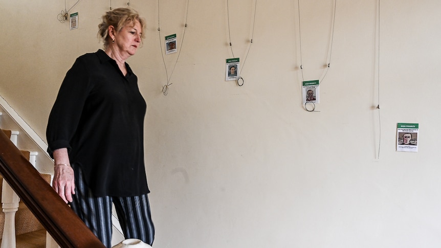 A woman walks down stairs  with wires in the background