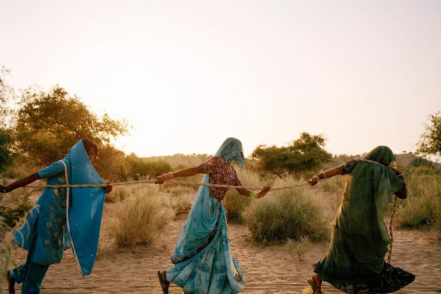 Women pull water from a well in high-40s heat in Bewatoo, Pakistan.