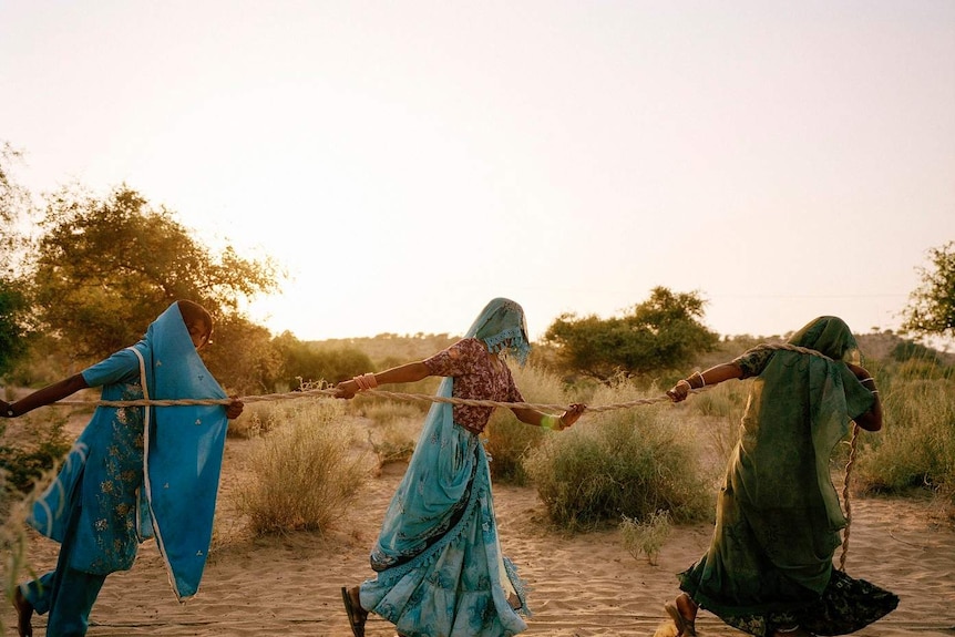 Women pull water from a well in high-40s heat in Bewatoo, Pakistan.
