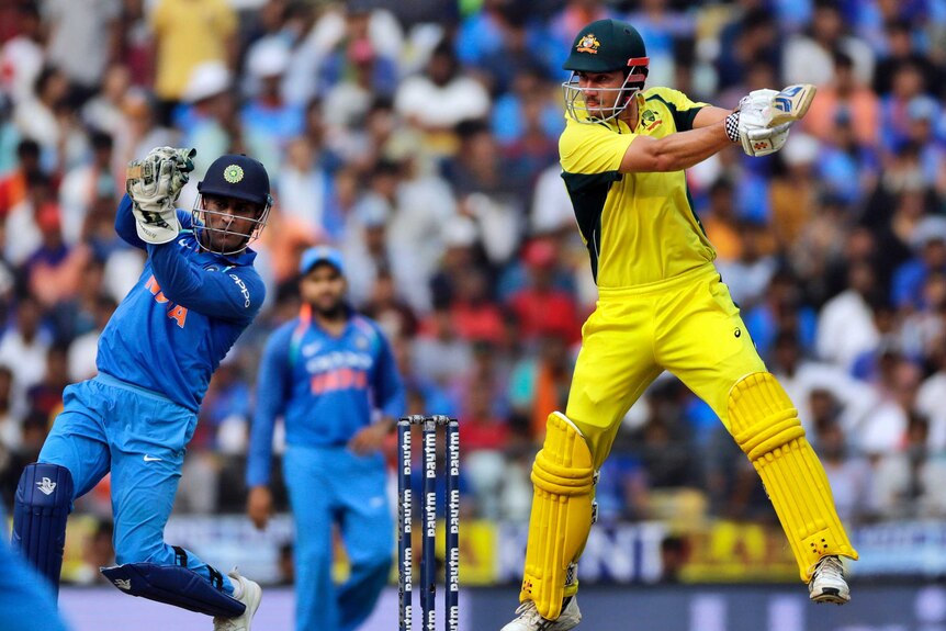 Australia cricket player Marcus Stoinis swings his bat.