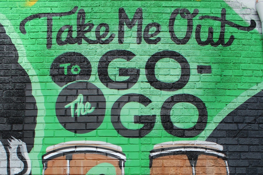 A green mural with the text "take me out to the go-go"