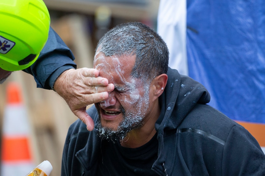 A demonstrator receives medial attention after he was sprayed by police at a protest