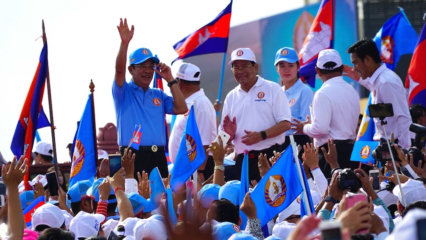 Cambodian Prime Minister raises his left hand to wave to a crowd