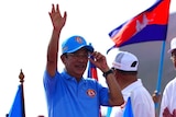 Cambodian Prime Minister raises his left hand to wave to a crowd