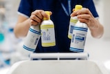 Health worker holds single-use bottles used to contain anaesthesia