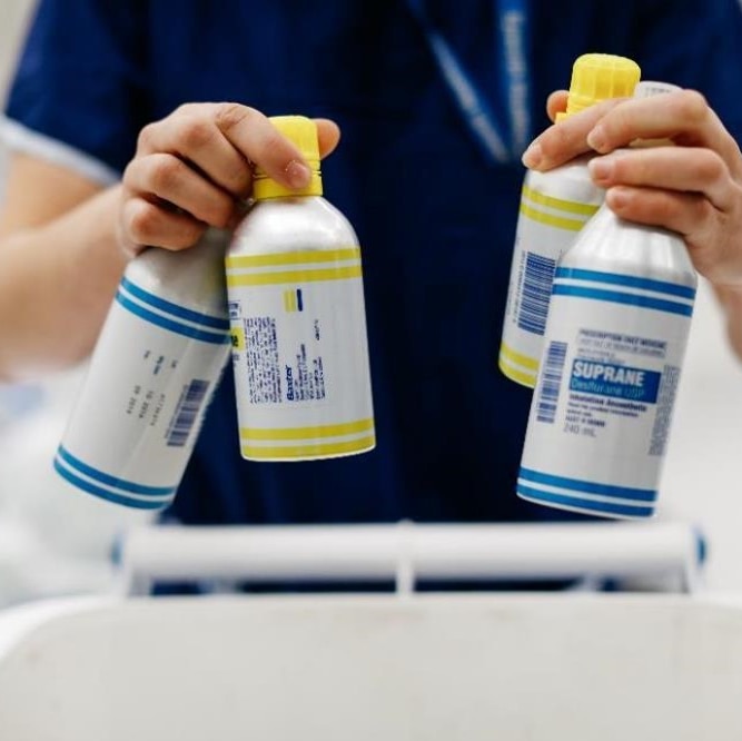 Health worker holds single-use bottles used to contain anaesthesia