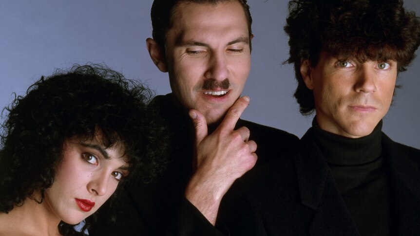 The Go-Go's Jane Wiedlin rests her head on Ron Mael's shoulder in pose with Russell Mael in The Sparks Brothers