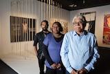Frank and Anwar Young and Rhonda Dick in front of their artwork, Many Spears - Young Fella Story.