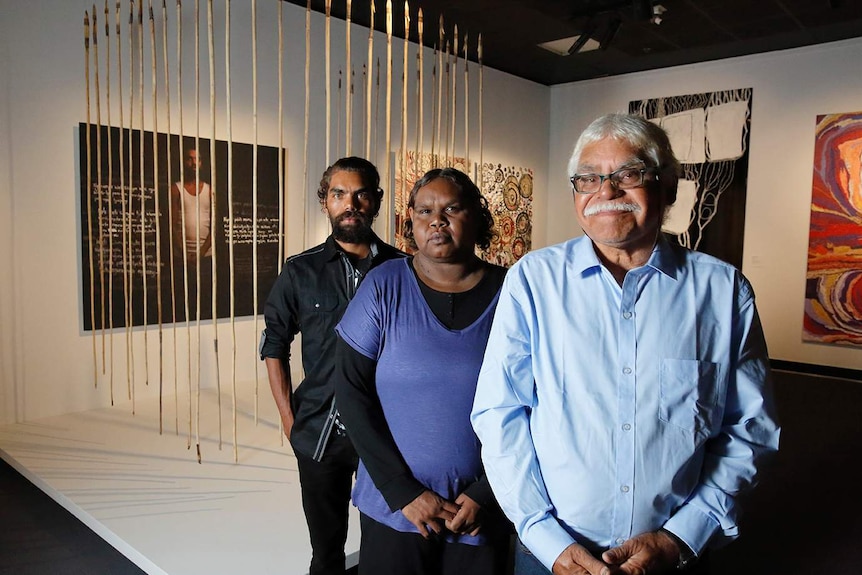 Frank and Anwar Young and Rhonda Dick in front of their artwork, Many Spears - Young Fella Story.