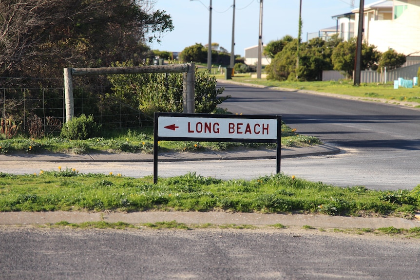 A small sign reading 'Long Beach' with a road and houses stretching behind.