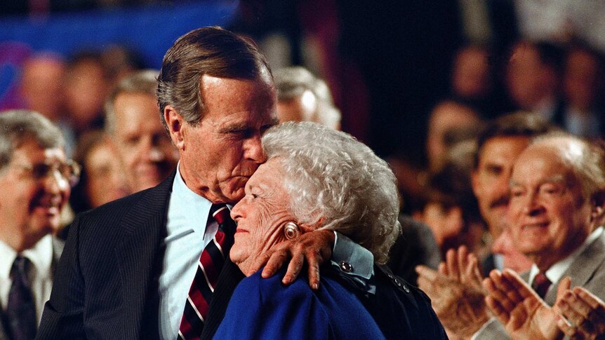 President George HW Bush kisses his wife Barbara Bush.