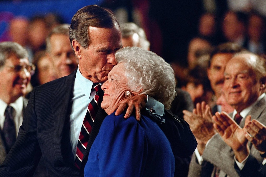 President George HW Bush kisses his wife Barbara Bush.