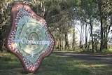Large entry statement for town of Cookernup beside a road and trees