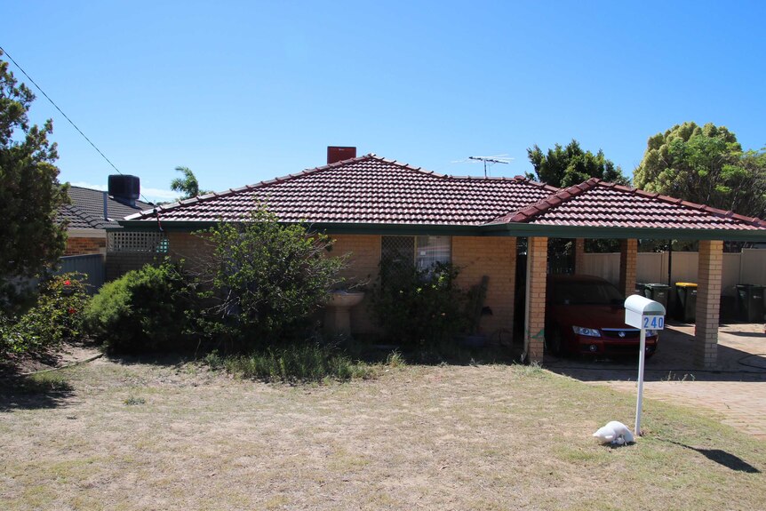 A wide shock of a brick and tile house in Beldon with a car in the carport and under a bright blue sky.