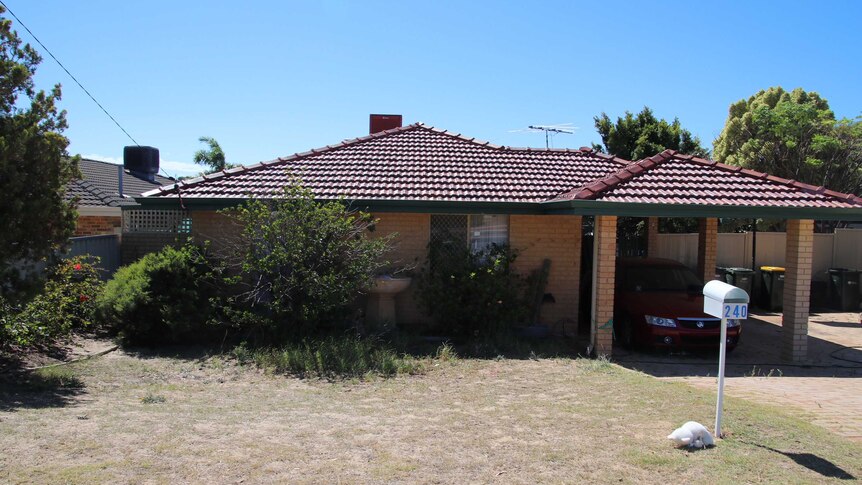 A wide shock of a brick and tile house in Beldon with a car in the carport and under a bright blue sky.