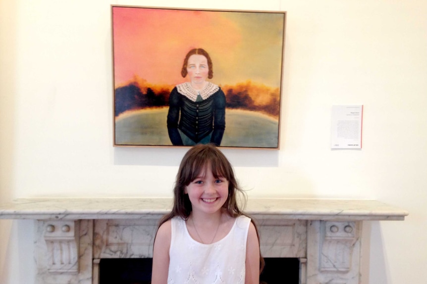 Megan Seres's daughter, Scarlett, poses in front of the Moran prize-winning portrait.