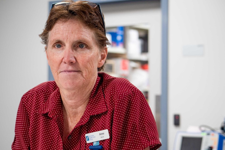 Anne Russell wearing a maroon shirt looking at the camera.