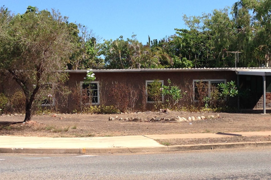 an empty house with brown lawn